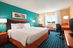 A hotel room with a large bed, a desk with a computer, a chair, and a television. - Fairfield Inn & Suites Lansing West (Lansing)