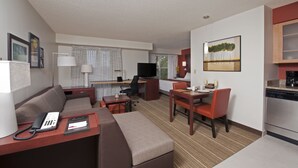 A compact hotel room with a living area, kitchenette, and a dining space. - Residence Inn Lansing West (Lansing)