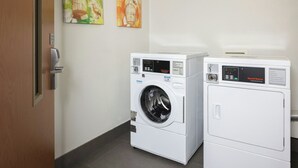 A laundry room with two front-loading washing machines and two dryers. - Fairfield Inn & Suites by Marriott® Grand Rapids Airport (Grand Rapids)