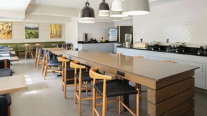 A modern kitchen with a central island, bar stools, and pendant lighting. - Fairfield Inn & Suites by Marriott® Grand Rapids Airport (Grand Rapids)