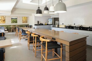 A modern kitchen with a central island, bar stools, and pendant lighting. - Fairfield Inn & Suites by Marriott® Grand Rapids Airport (Grand Rapids)