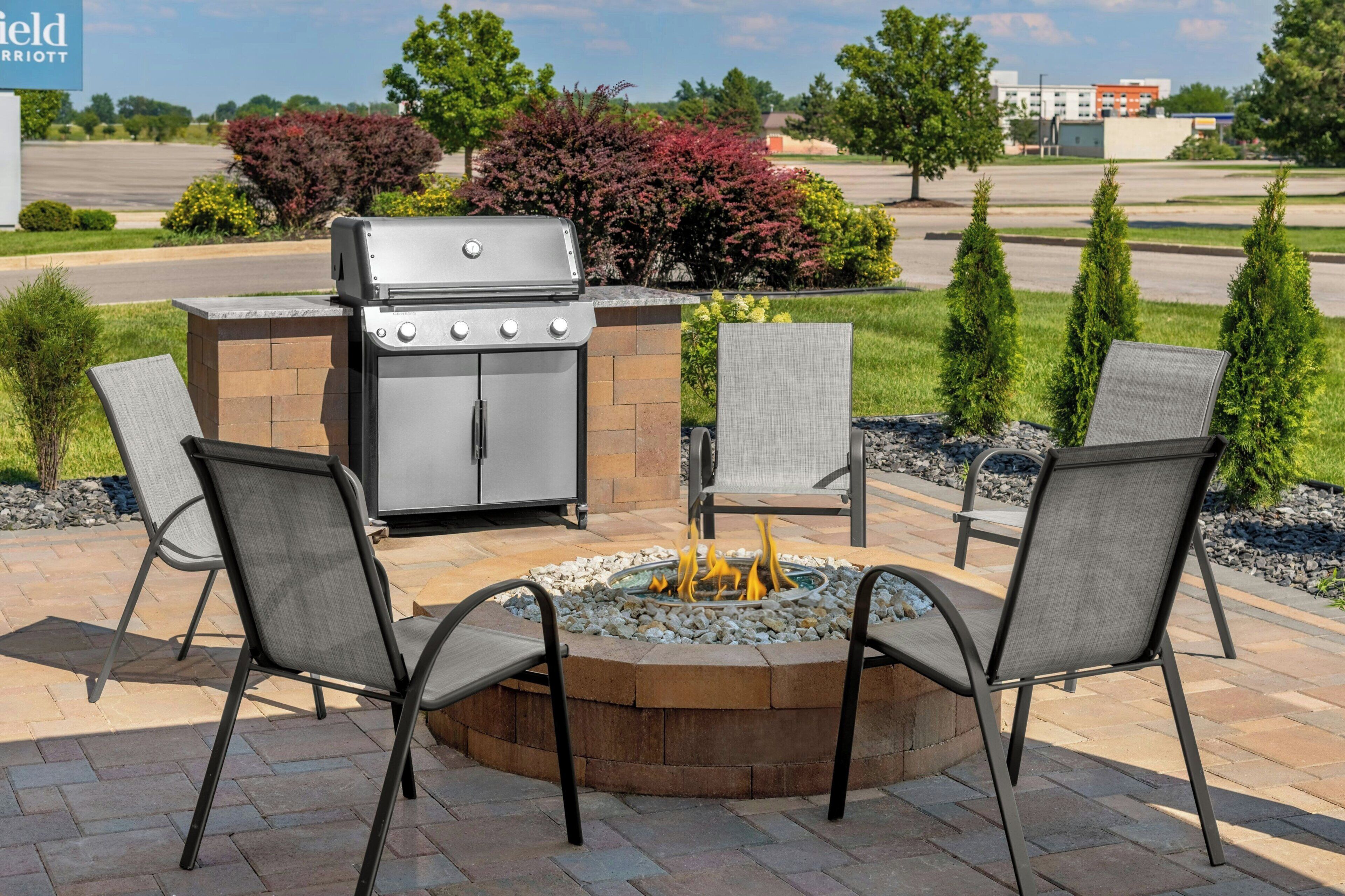 Une terrasse extérieure équipée d’un barbecue, d’un foyer et d’un espace salon.