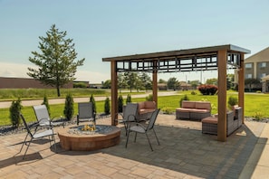 An outdoor patio area with a fire pit, seating, and a pergola structure. - Fairfield Inn & Suites Saginaw (Saginaw)