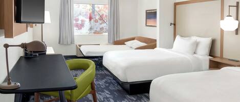 A hotel room with two beds, a desk, a chair, a TV, and a window with curtains.