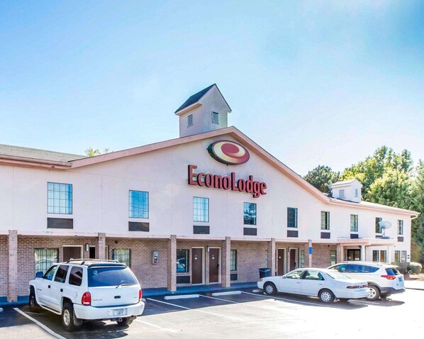 Een EconLodge gebouw met twee verdiepingen, een centrale ingang, parkeerplaats en een klein torentje op het dak.