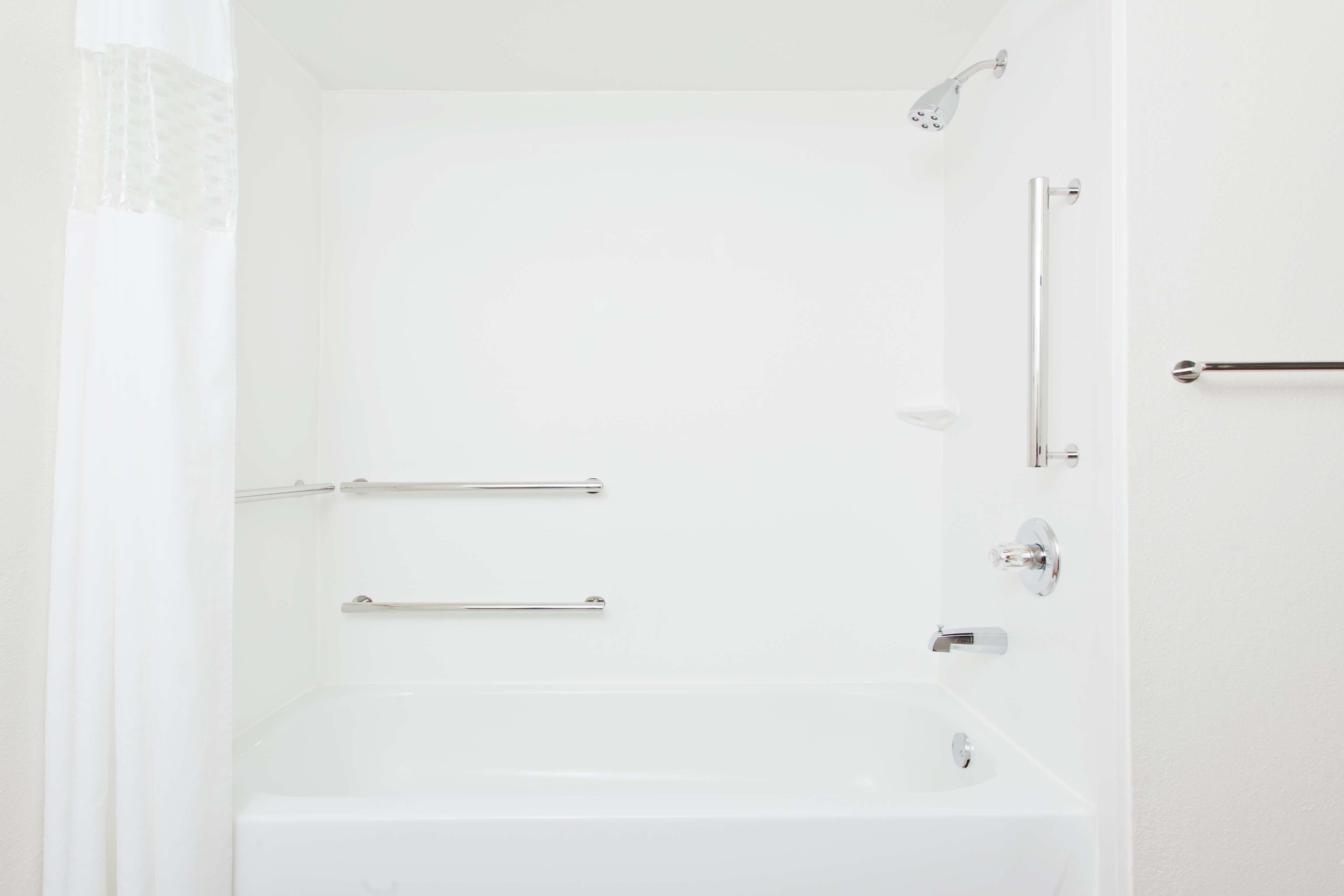 Ein helles Badezimmer mit Badewanne, Dusche und Toilette.