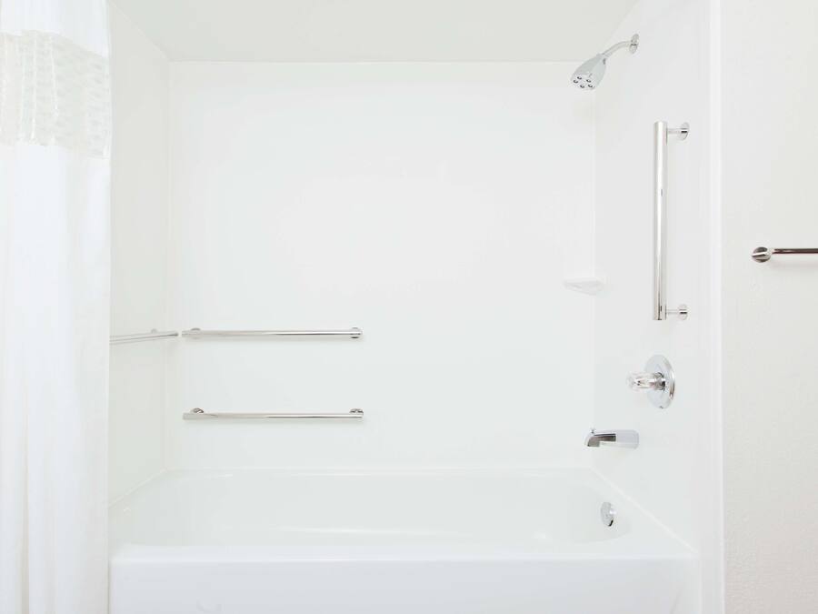 Ein helles Badezimmer mit Badewanne, Dusche und Toilette.