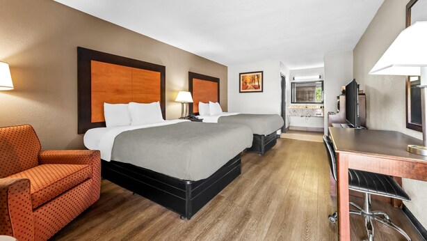 A hotel room with two beds, a desk, a chair, and a TV. - Quality Inn Richland - Jackson South (Richland)