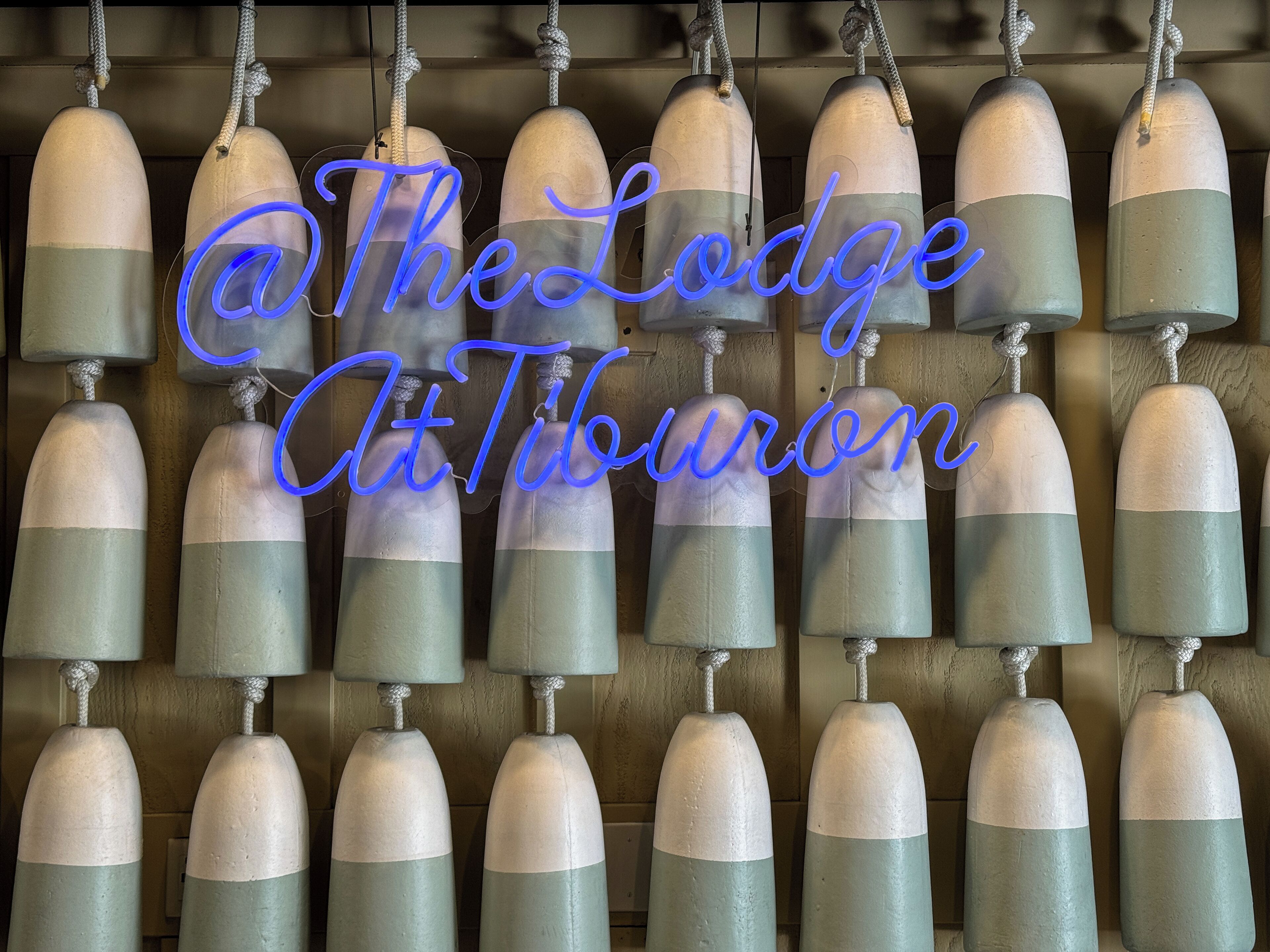 Una fila de boyas colgando del techo, con el texto “@The Lodge At Tiburon” superpuesto.