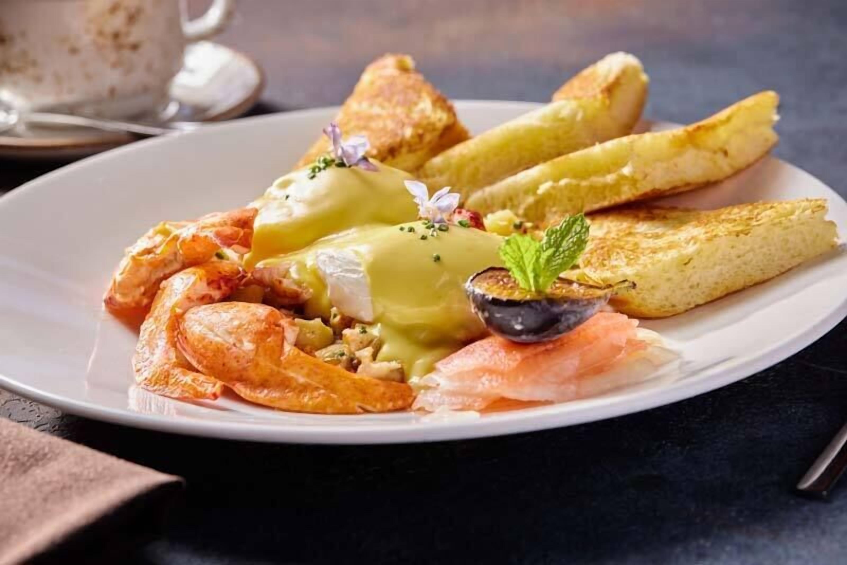 A plate of food with shrimp, eggs, and potatoes.