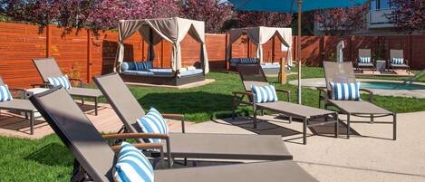 A poolside area with lounge chairs and a canopy.