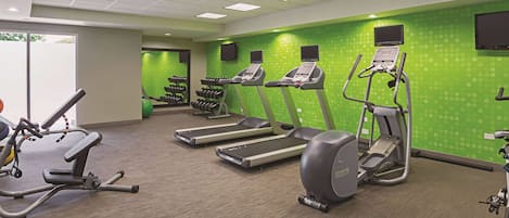 A fitness center with treadmills, elliptical machines, and a weight rack.