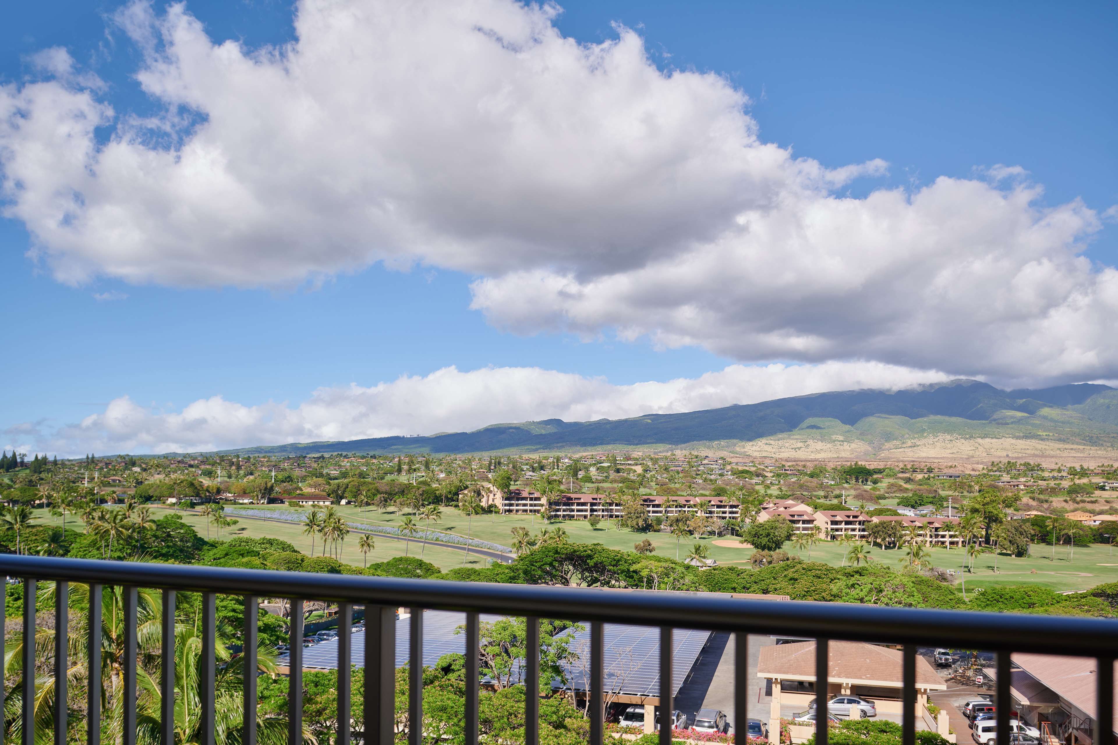 A coastal resort with a view of the ocean, a golf course, and a mountainous backdrop.