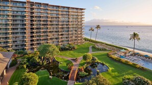 A multi-story hotel with a pool, garden, and ocean view.