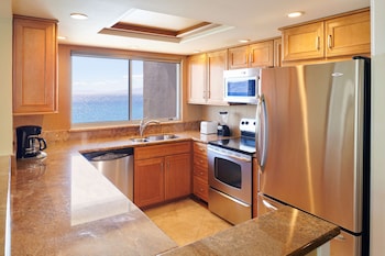 A spacious lobby with a central dining area, comfortable seating, and large windows offering views of the outdoors. at Aston at The Whaler on Kaanapali Beach