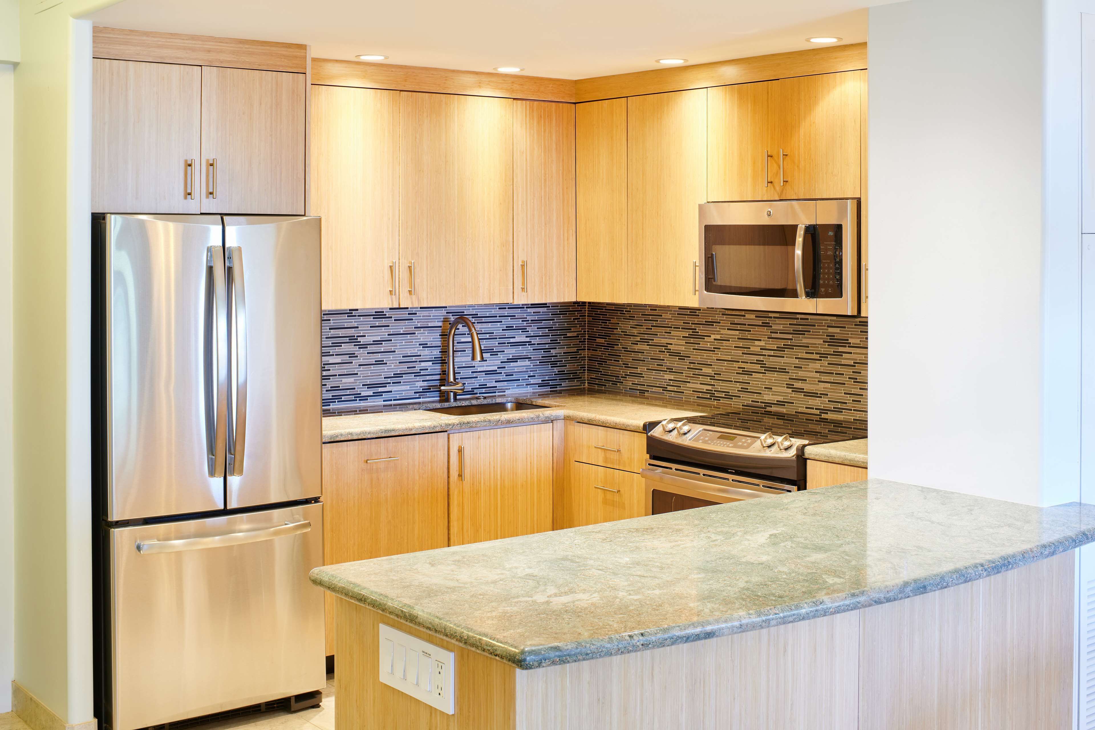 Una cocina moderna con armarios de madera, electrodomésticos de acero inoxidable y encimera de granito.