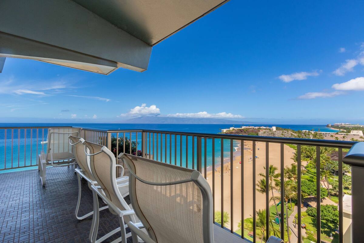 A balcony with a view of a beach and ocean.