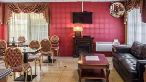 Habitación de hotel con comedor, chimenea, televisor y sofá de cuero.