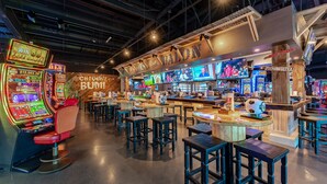 A casino interior with slot machines, bar area, and multiple gaming tables. - Hotel Jefe at Ojos Locos- No Resort Fee (North Las Vegas)