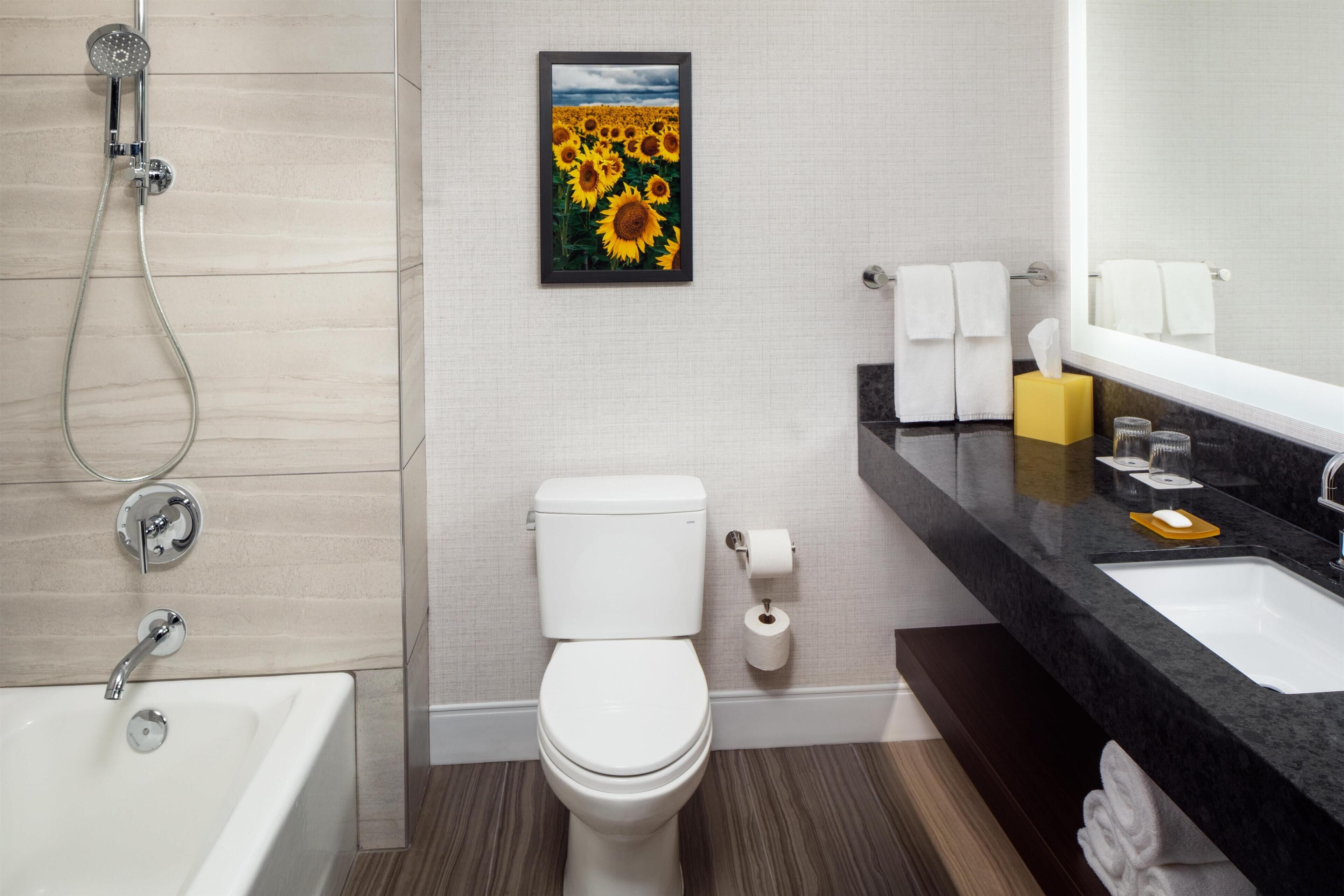 A modern bathroom with a bathtub, toilet, sink, and shower.