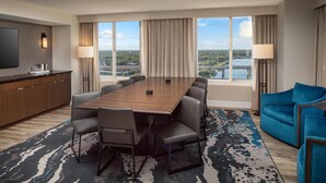 A hotel room with a large conference table, a sofa, and a TV. - Hyatt Regency Wichita (Wichita)