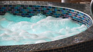 A hot tub with a mosaic tile border.