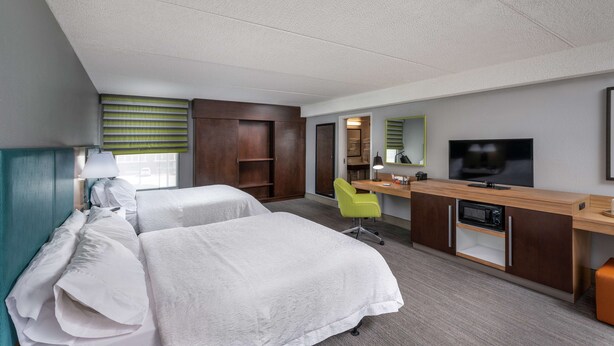 A hotel room with two beds, a desk with a TV, a chair, and a kitchenette. - Hampton Inn Tuscaloosa-East (Cottondale)