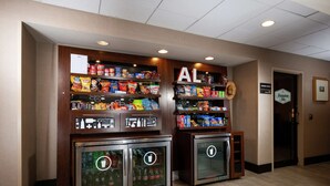A vending machine area with snacks and drinks, a sign for the business center, and a Hampton Inn sign. - Hampton Inn Tuscaloosa-East (Cottondale)