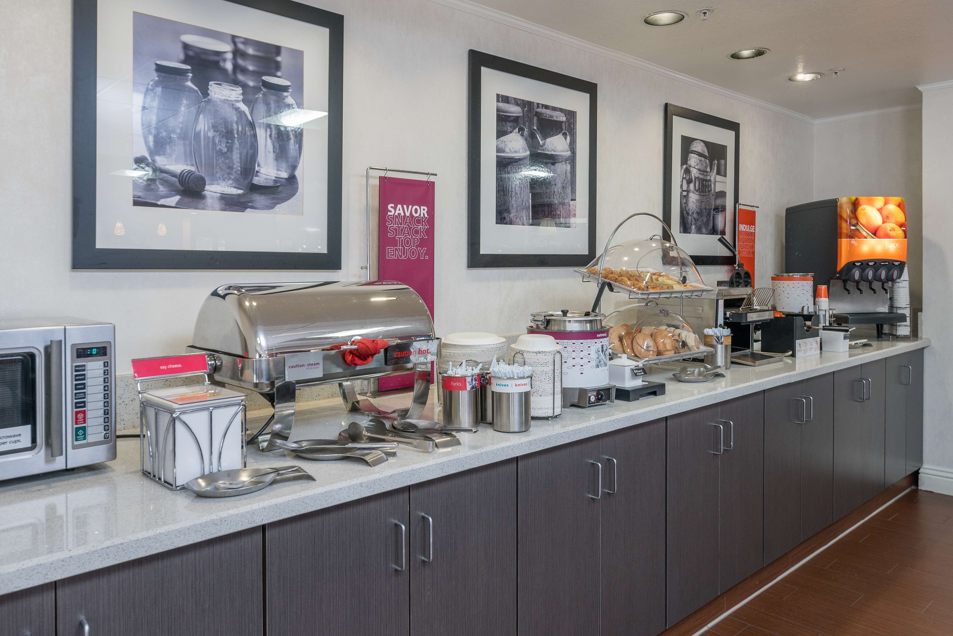 A breakfast bar with a coffee machine, toaster, and various food items.