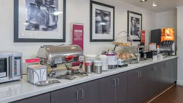A breakfast bar with a coffee machine, toaster, and various food items.