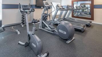 A gym with treadmills, an elliptical, and free weights.