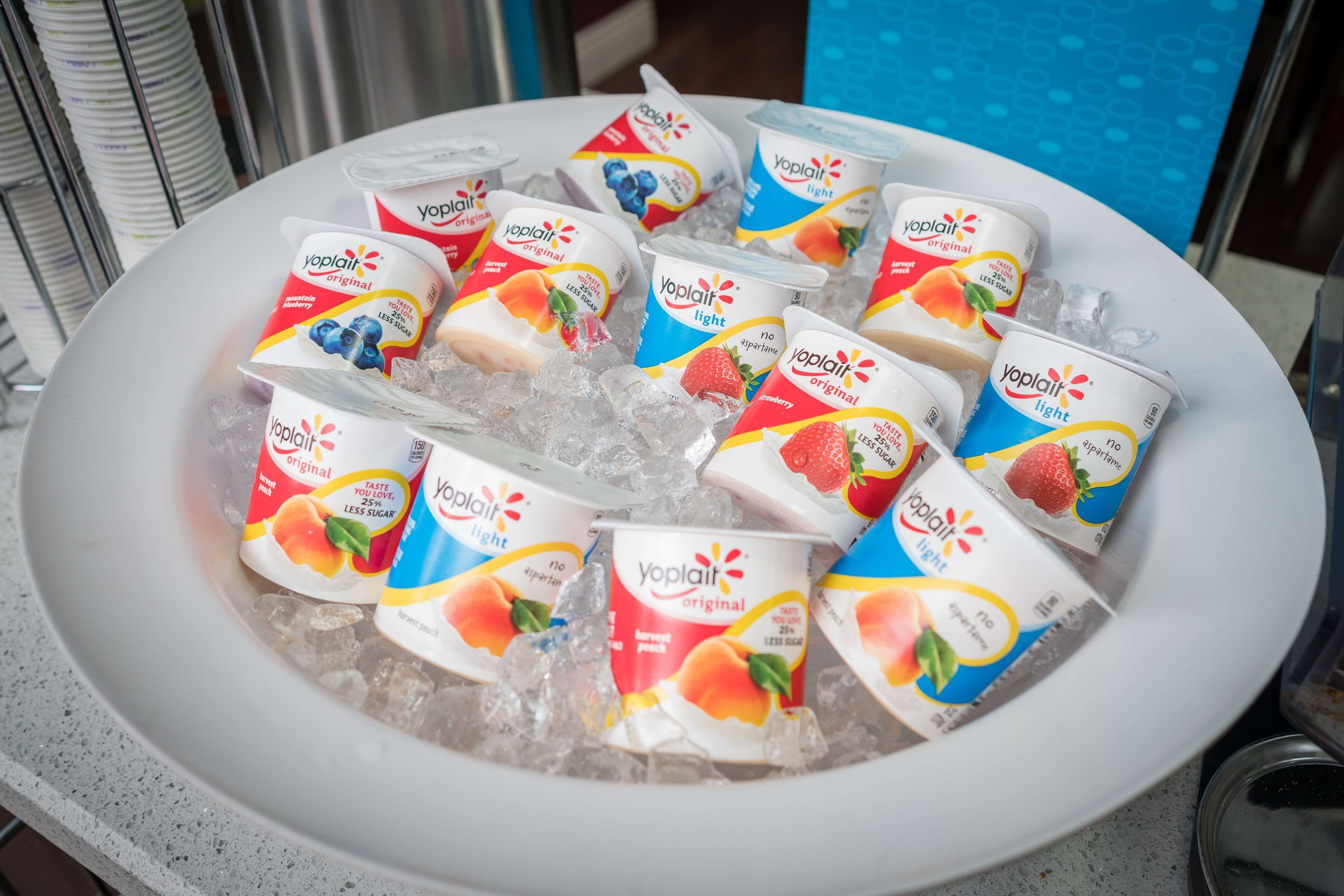 A bowl of ice with Yoplait yogurt cups in various flavors.