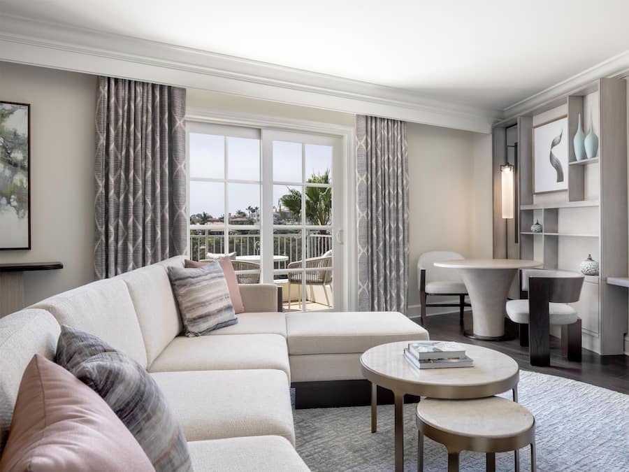 A modern living room with a sectional sofa, a round coffee table, and a dining area with a table and chairs.