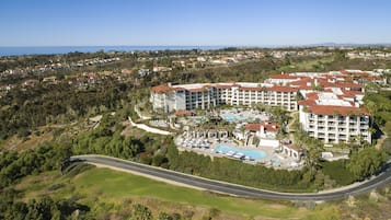A resort with multiple buildings, a swimming pool, and a road curving through the landscape.