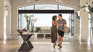 A spacious room with a modern chandelier, a large arched window, and a view of the outdoors. - Park Hyatt Aviara Resort, Golf Club & Spa (Carlsbad)