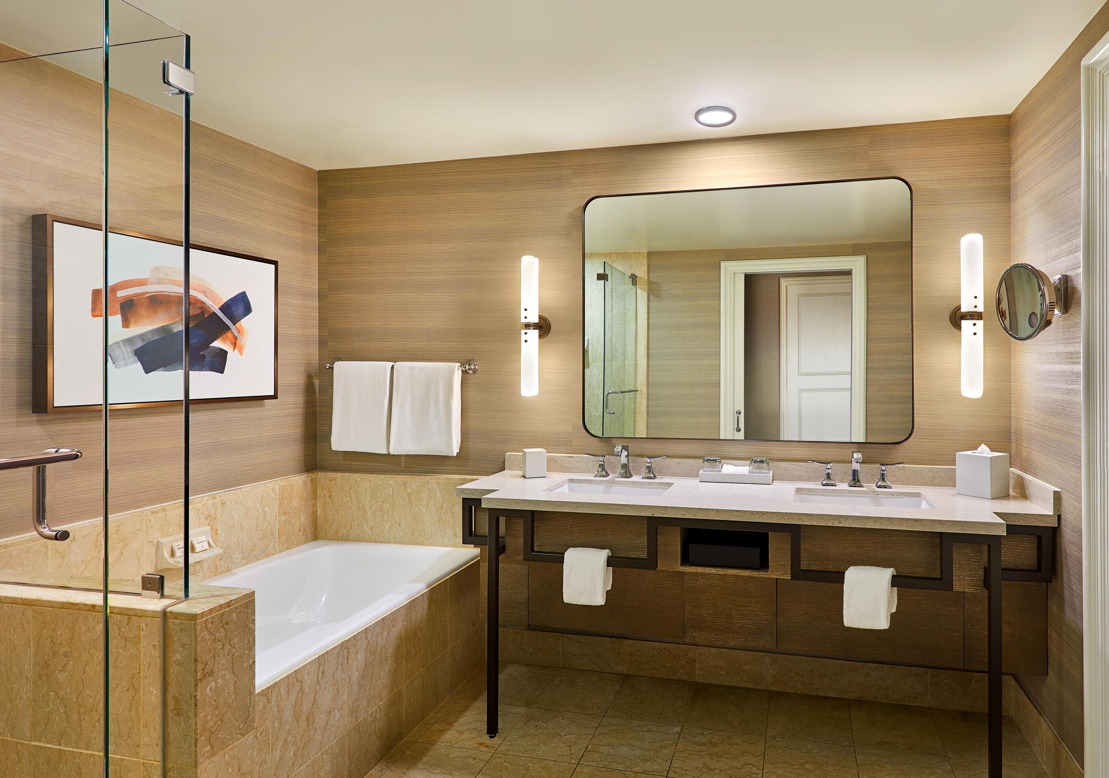 A modern bathroom with a glass shower enclosure, a double sink vanity, and a large mirror.