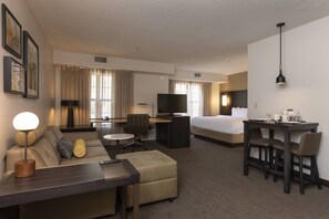 A hotel room with a sofa, a desk, a bed, a TV, and a dining table. - Residence Inn by Marriott Durango Downtown (Durango)