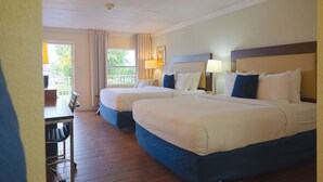 Een hotelkamer met twee bedden, een bureau en een raam met gordijnen.