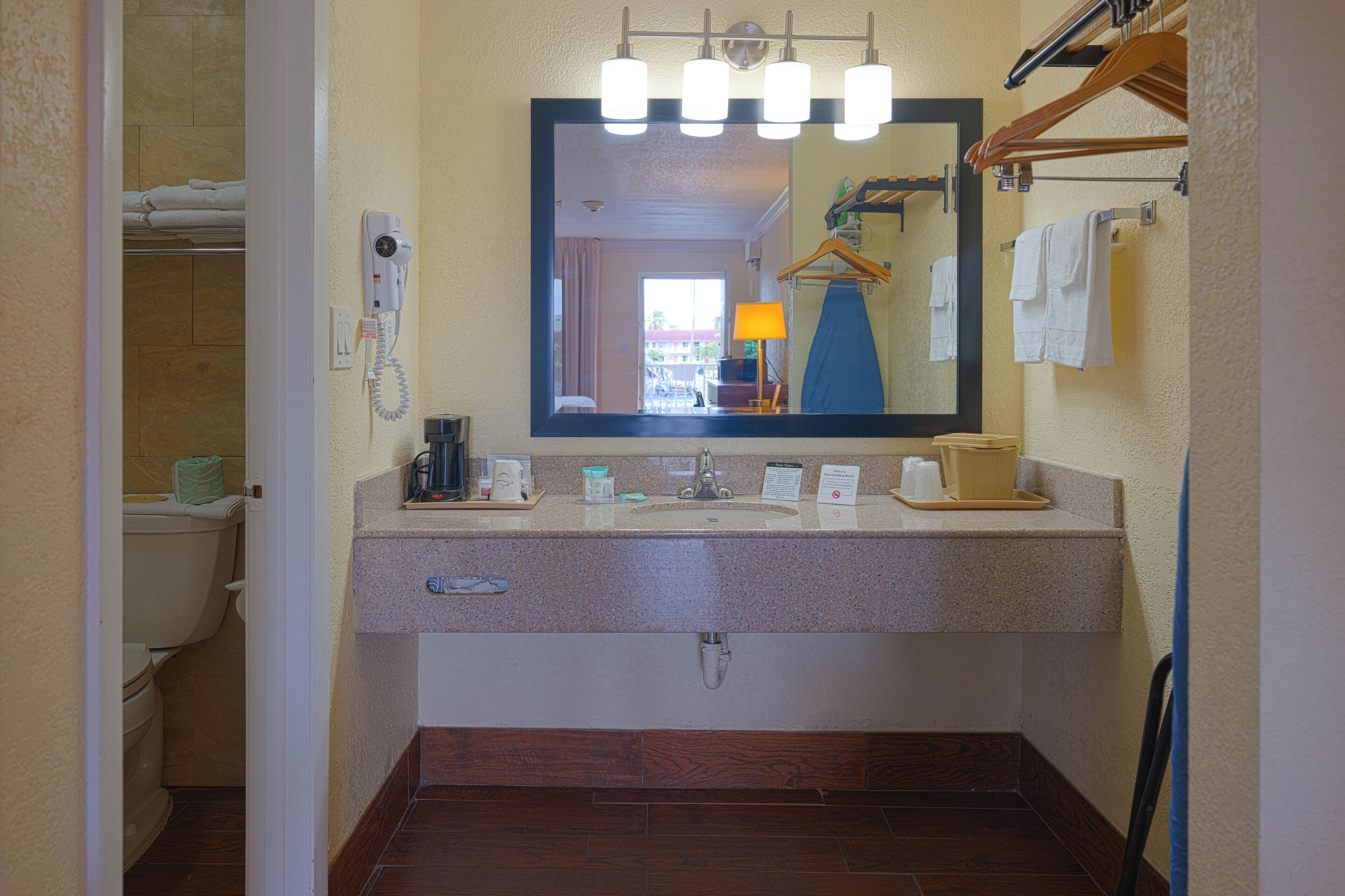 Une salle de bain équipée d’un lavabo, d’un miroir, d’un porte-serviettes et de toilettes.