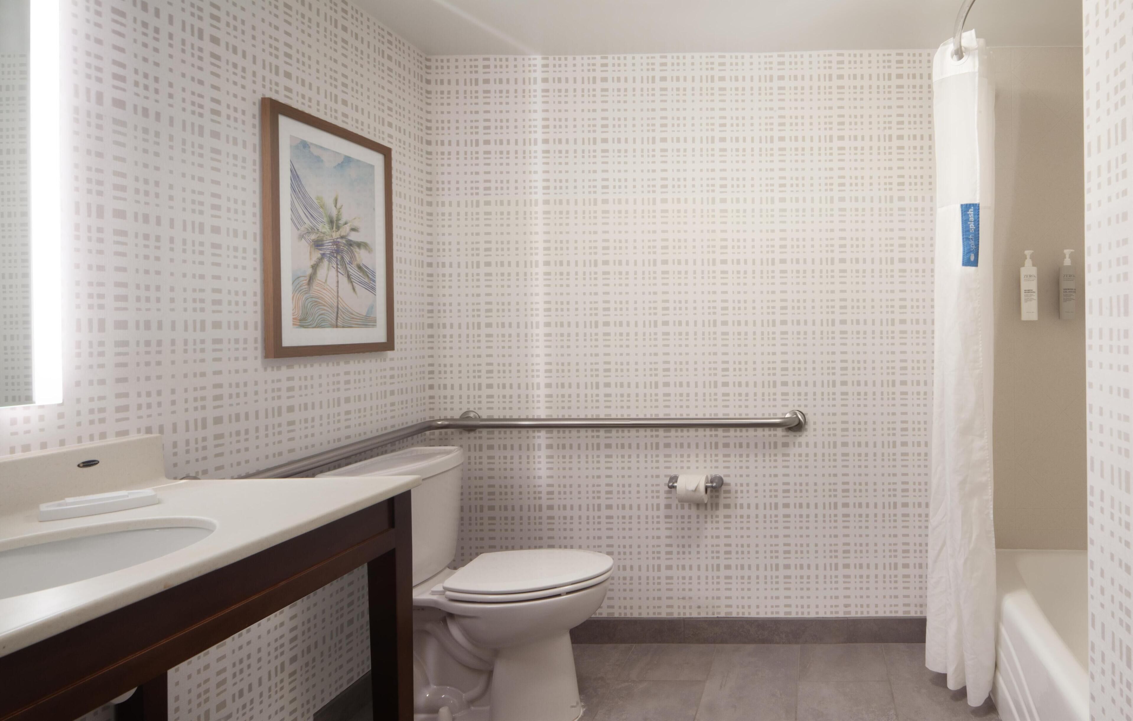 A bathroom with a toilet, sink, and shower area.