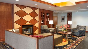 A lobby with a fireplace, seating area, and a decorative wall. - Hampton Inn Columbus/Taylorsville/Edinburgh (Edinburgh)