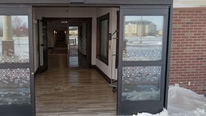 Ein Hotel mit Glastüren, Holzboden und einer Ziegel-Fassade.