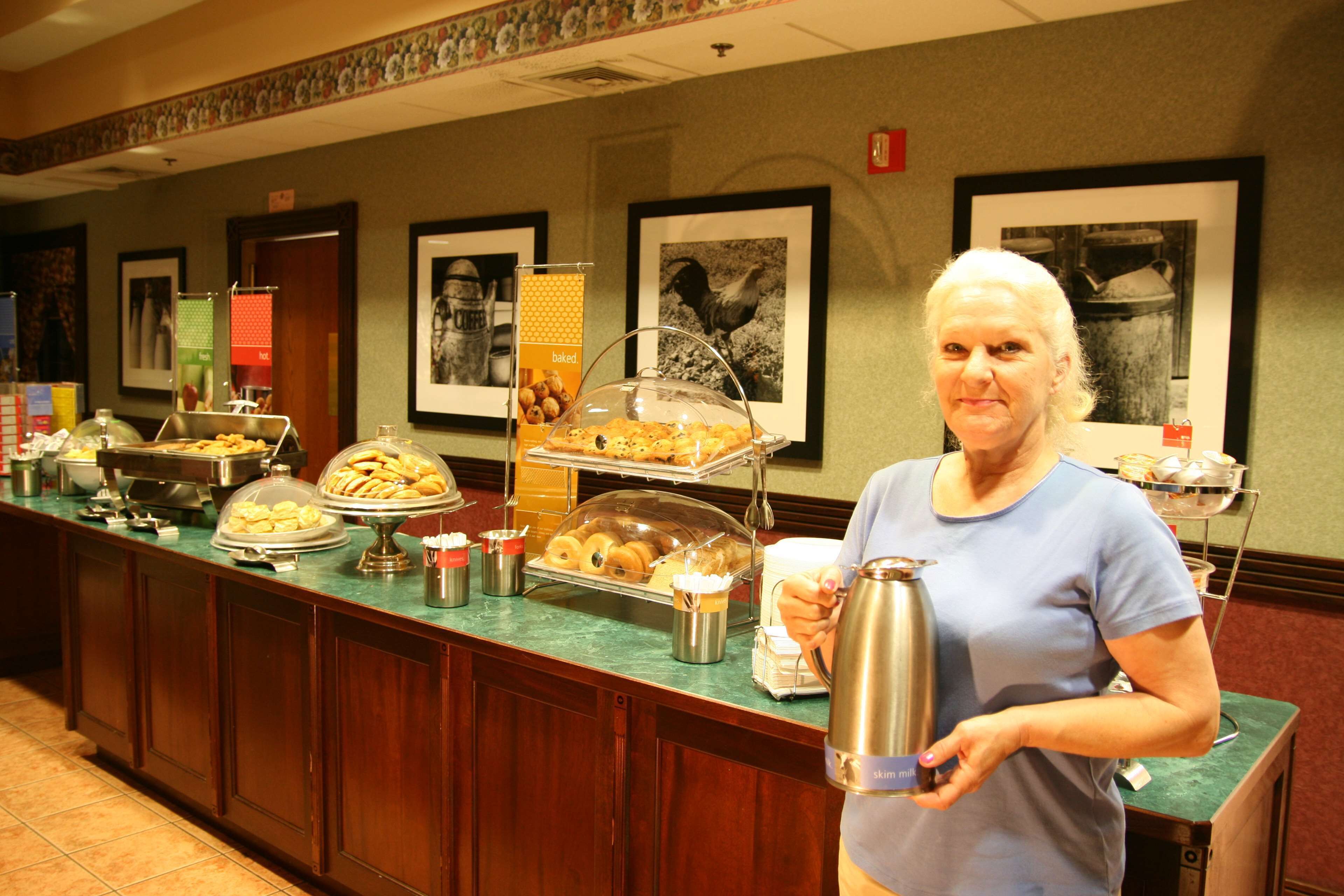 A buffet counter with various food items and a coffee pot.