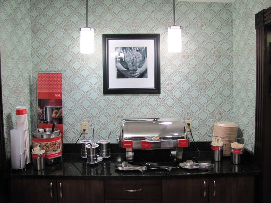 A kitchenette with a toaster, coffee maker, and various containers for food and utensils.