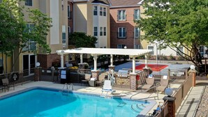 A swimming pool with lounge chairs and a covered patio area. - Homewood Suites by Hilton Kansas City-Airport (Kansas City)