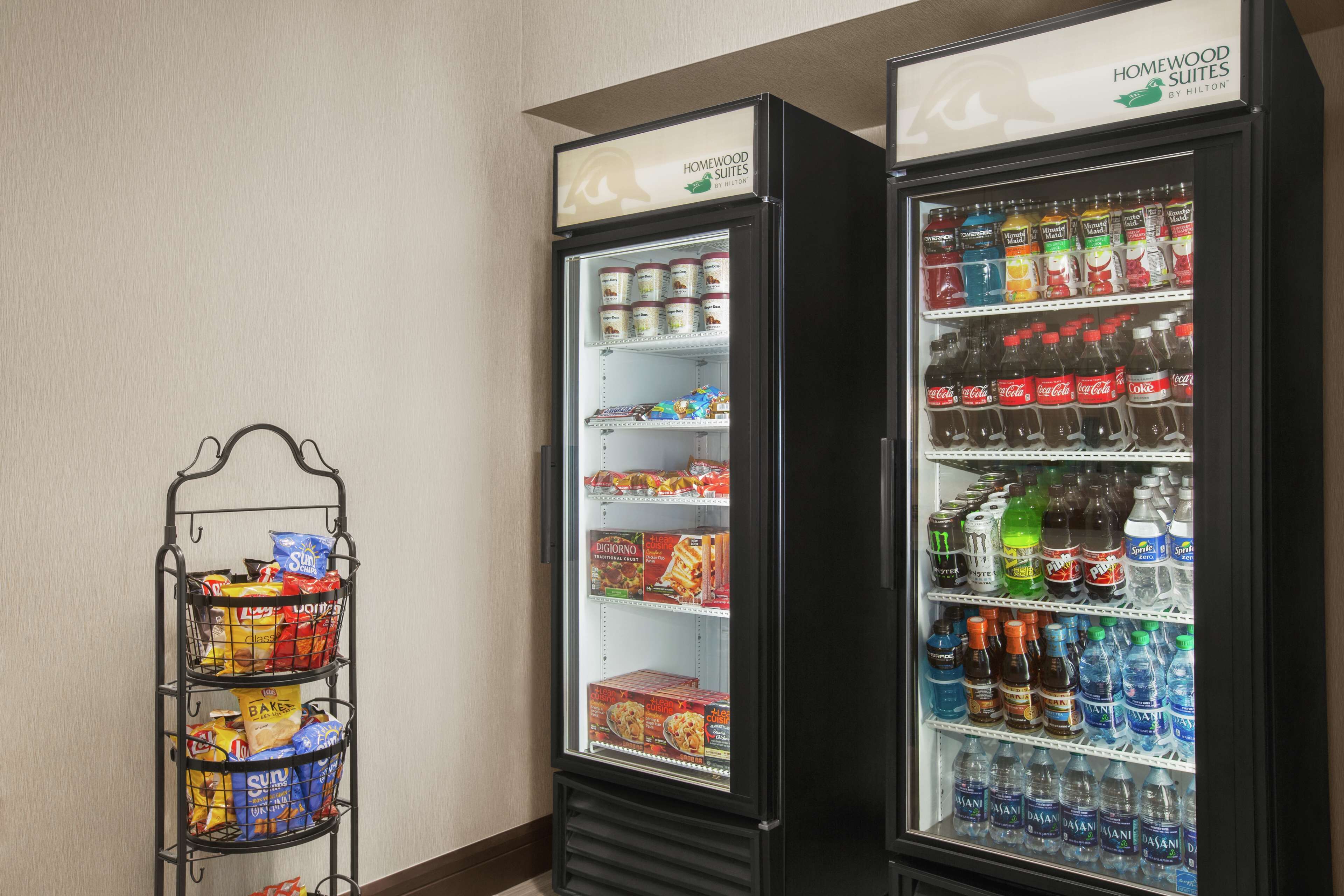 Two beverage dispensers with a snack rack beside them.