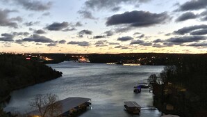 A river with boats docked, a bridge in the distance, and a view of the surrounding landscape.