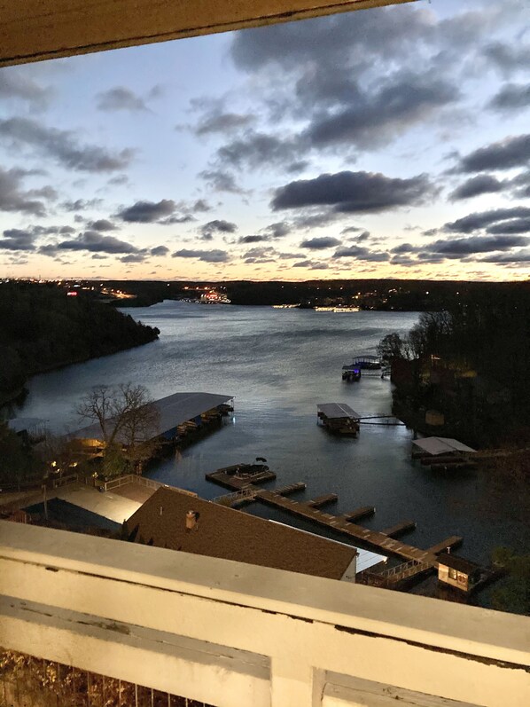A river with boats docked, a bridge in the distance, and a view of the surrounding landscape. - Inn at Grand Glaize (Osage Beach)