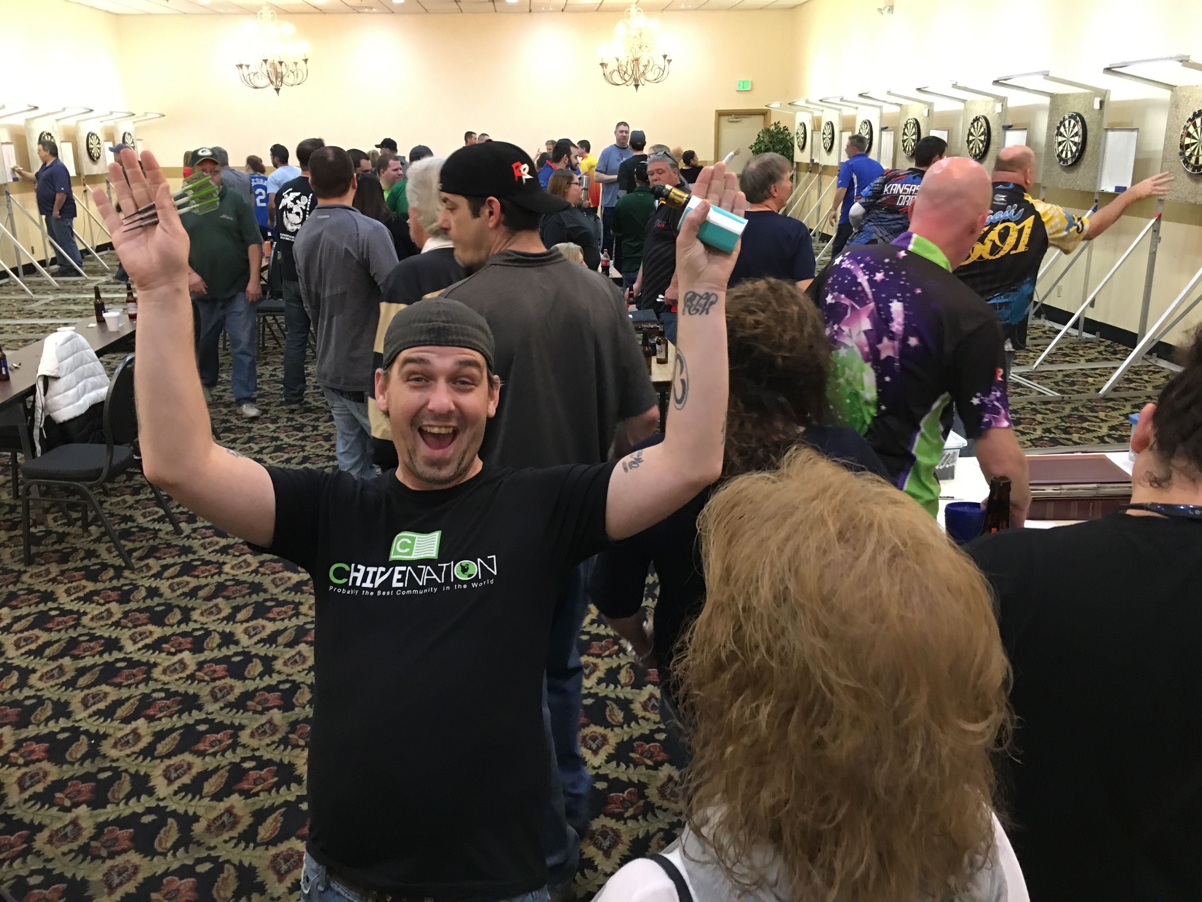 Un evento en interiores concurrido, con gente de pie e interactuando.
