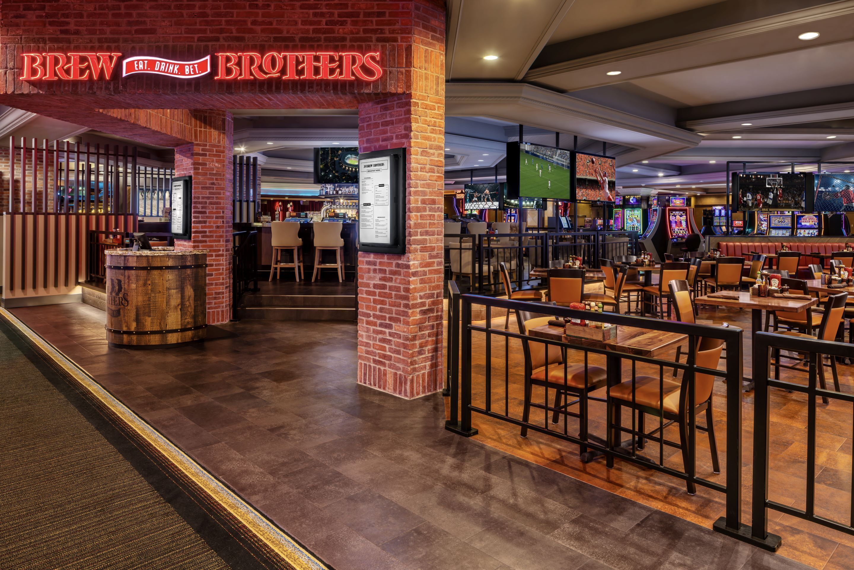 Un restaurante llamado 'Brew Brothers' con fachada de ladrillo, zona de bar y máquinas de juego.